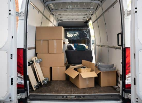 Loaded moving van with packed boxes and furniture ready for transport